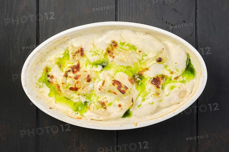Overhead view of pork dumplings with mushroom and onion sauce baked in oven