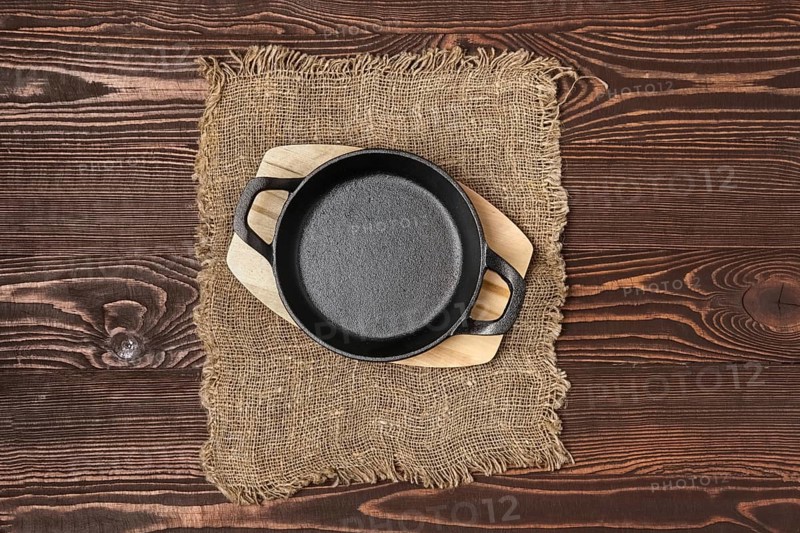 Empty mini cast-iron skillets on wooden table