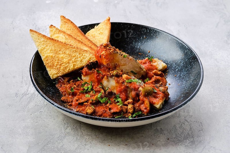 Fried zander served with steamed tomato