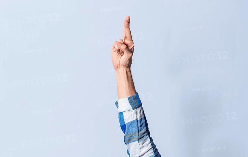Hand gesturing the letter R in sign language on an isolated background. Man's hand gesturing the letter R of the alphabet isolated. Letter R of the alphabet in sign language