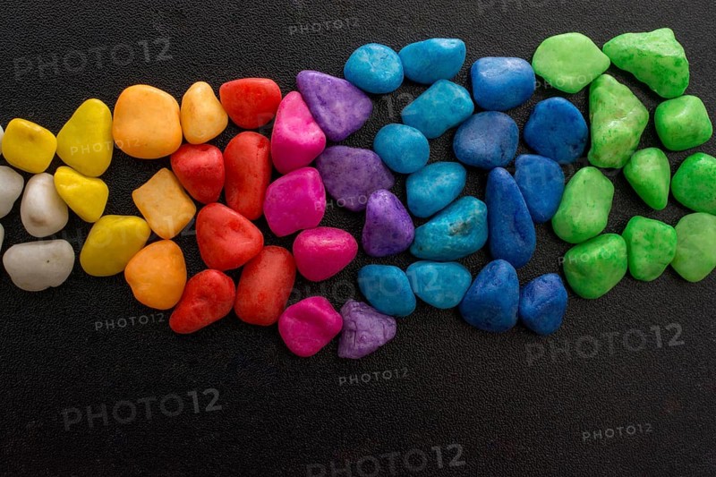 Pile of little colorful pebbles on black background