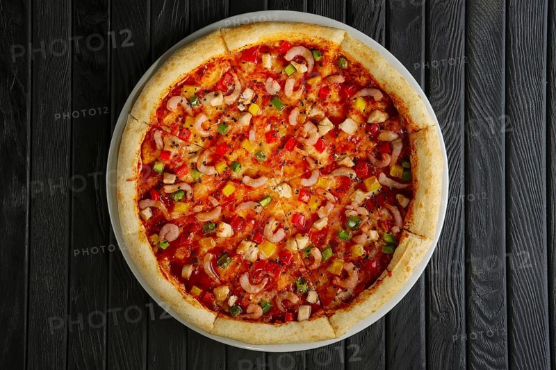 Top view of pizza with shrimps and chicken fillet