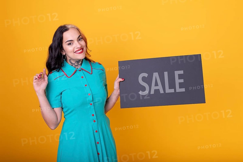 Beautiful woman holding a Sale sign. Commercial concept