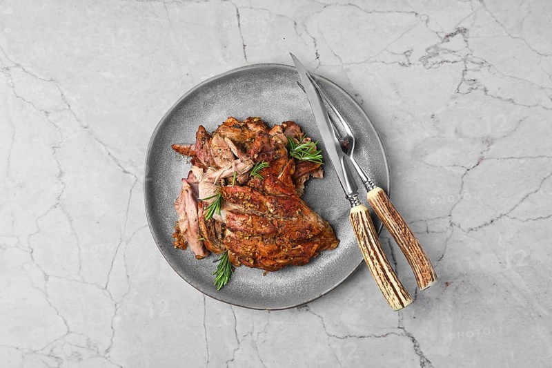Top view of pulled lamb meat baked in oven on marble table