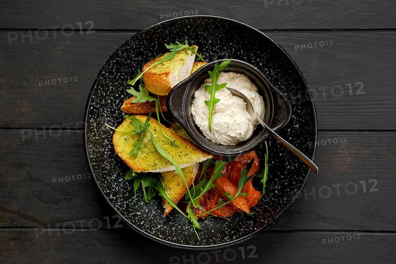 Top view of crispy toasted garlic bread with sour curd and braised tomato