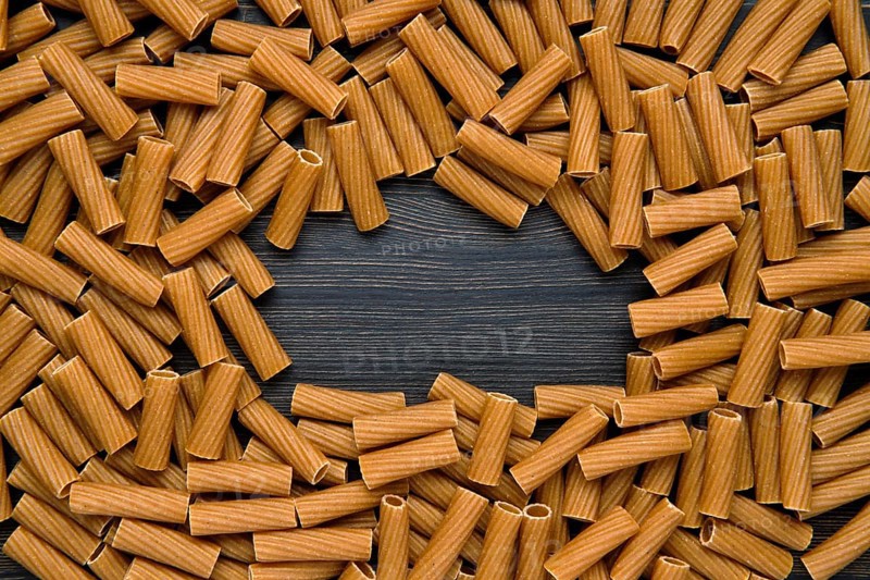 Top view of tortiglioni pasta with copy space place. Grooved helical tube pasta