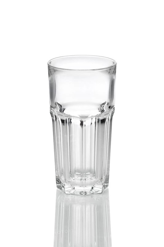 Empty transparent faceted glass with reflection on white background