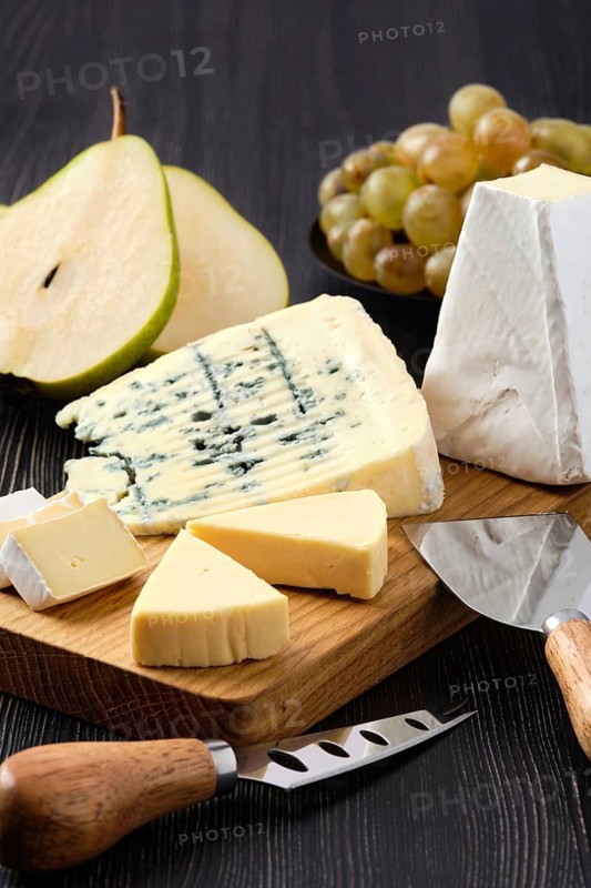 Assortment of cheese and snack for wine on dark wooden table