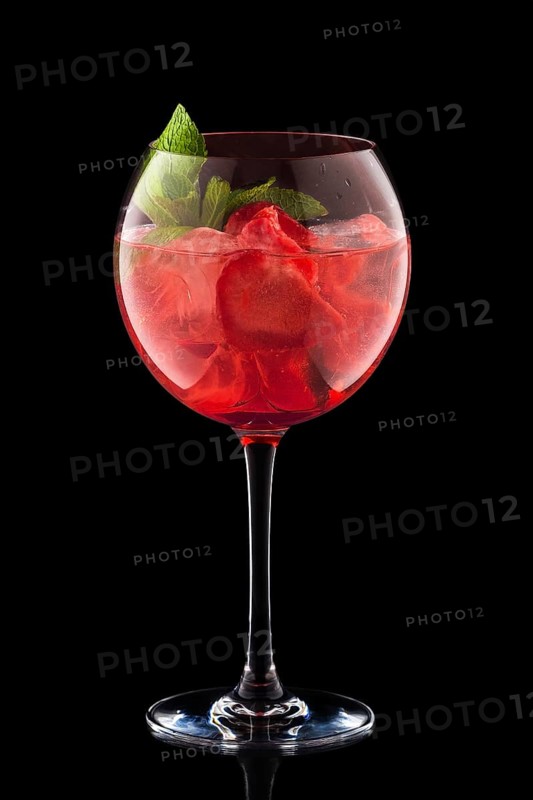 Big round wine glass with fresh cold lemonade isolated on black background