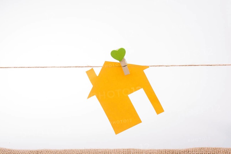 Little paper house attached to a string with a heart clip