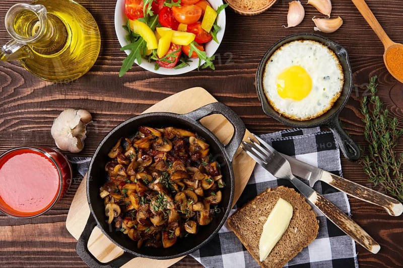 Fried mushrooms and egg in cas-iron skillet. Ingredients for rustic simple food