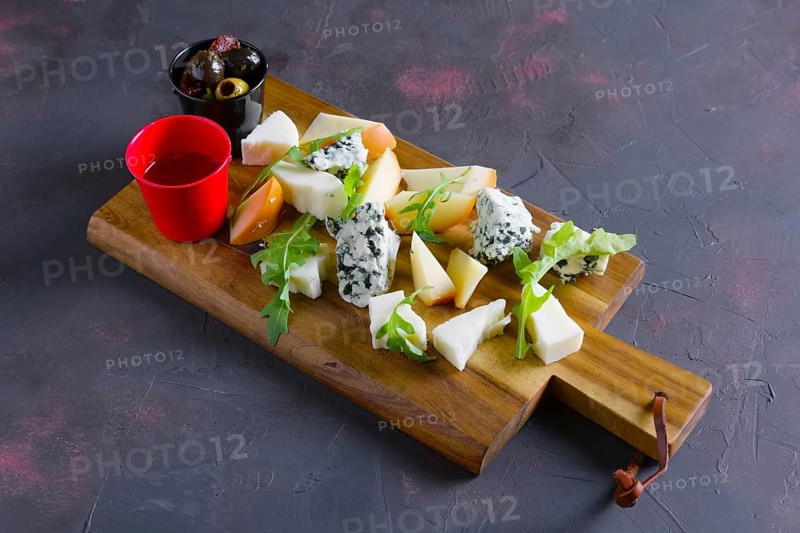 Cheese plate with honey and black and yellow olives