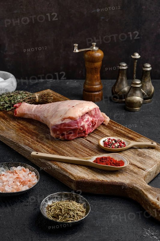 Raw turkey drumstick with skin on wooden board