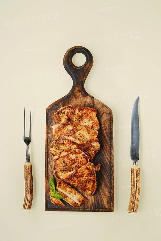Overhead view of fried chopped pork tenderloin on wooden cutting board