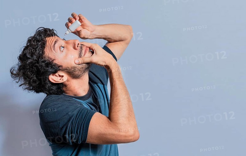 People applying refreshing drops to irritated eye. Man putting a dropper in his eye isolated. Man with irritated eye applying drops with a dropper