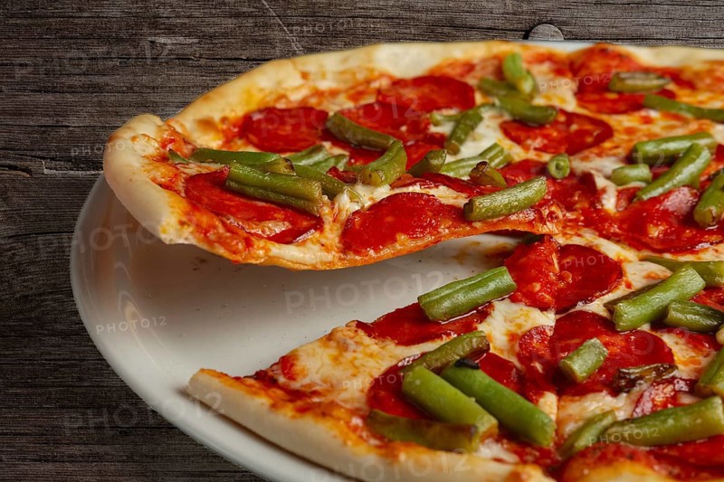 Slice of pizza pepperoni on scapula. Levitatating piece of pizza