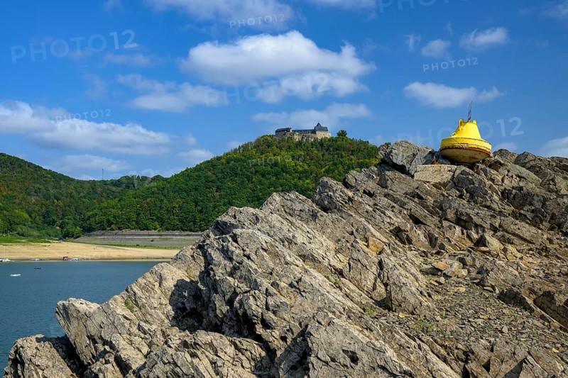Dry buoy in front of Waldeck Castle at low water in Lake Edersee