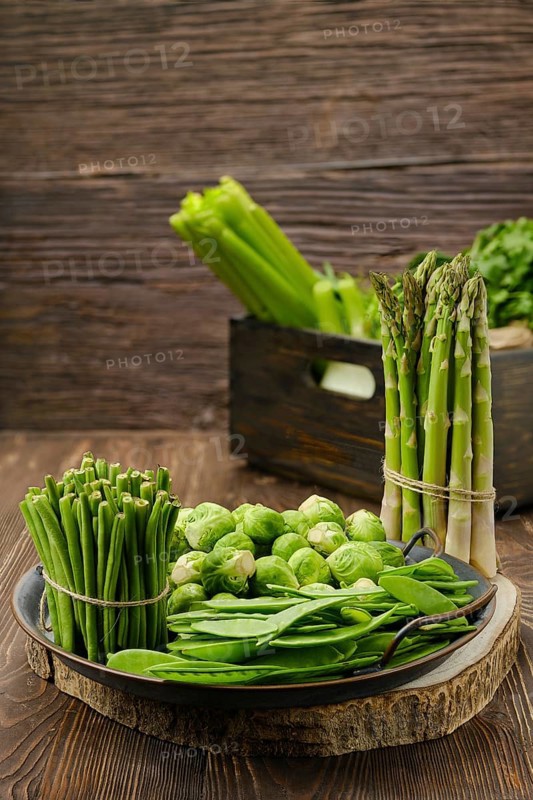 Various fresh green vegetables on wooden background
