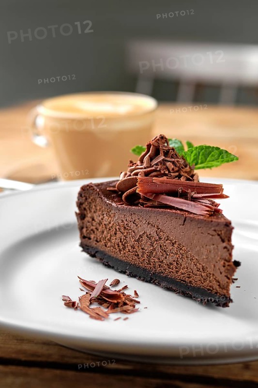 Close up view of piece of chocolate cake with cappuccino