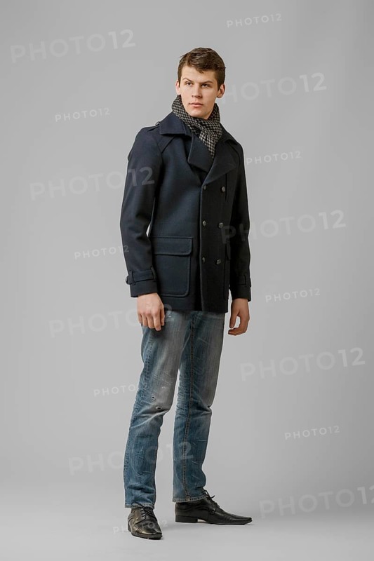 Full length portrait of handsome man in warm winter coat posing in studio