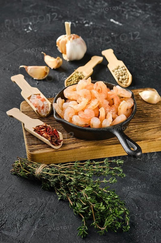Frozen peeled shrimps in frying pan