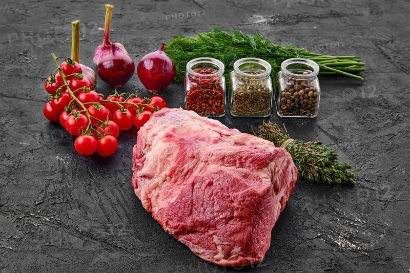 Raw fresh pork leg joint meat with spice on black background