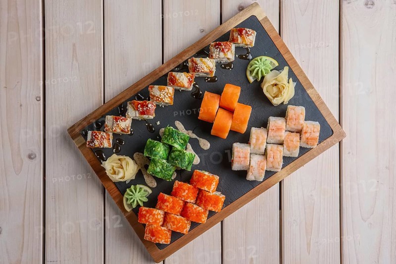 Big set of rolls served on stone plate