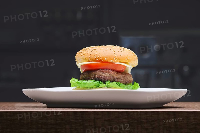 Fresh tasty burger on plate on wooden table