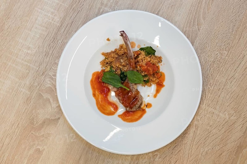 Top view of fried lamb rib with quinoa porridge on wooden table