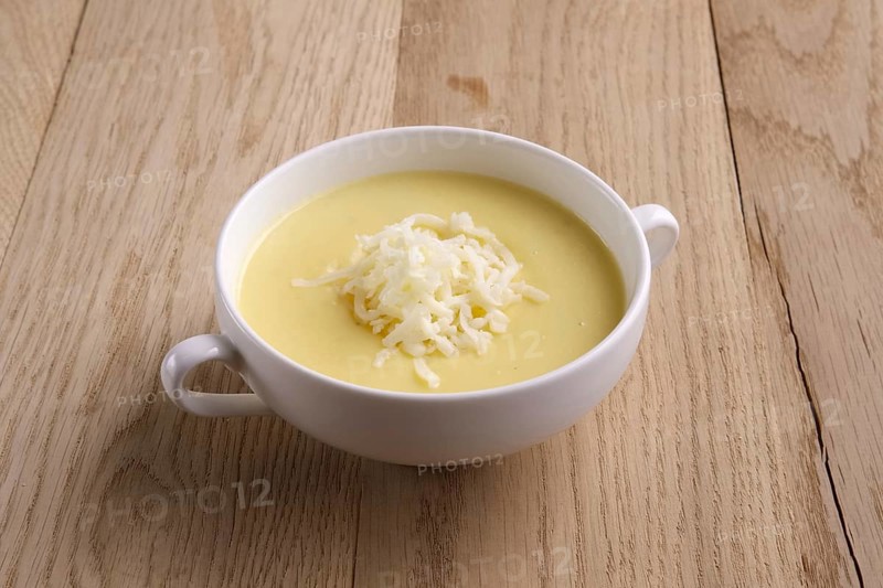 Soup puree with cheese and mushrooms on wooden table