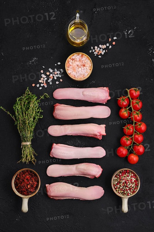 Composition with fresh raw lamb tongue with spice and herbs
