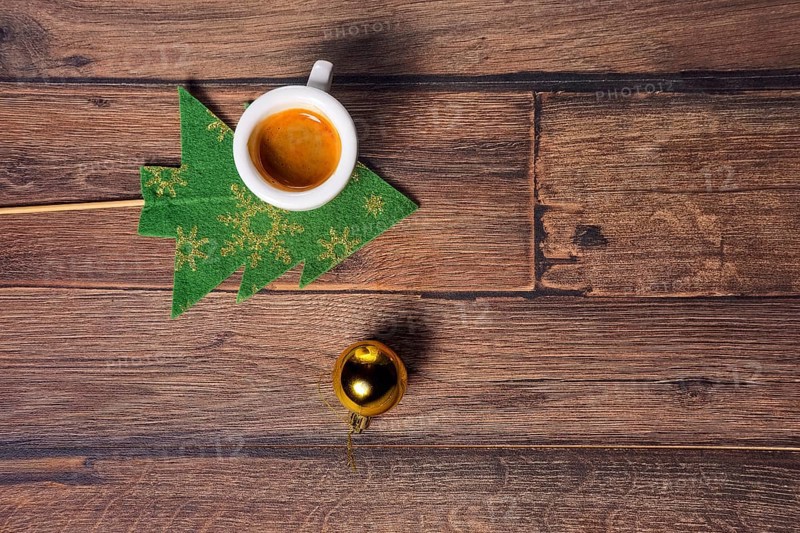 Top view of coffee cup and christmas tree toys on wooden table