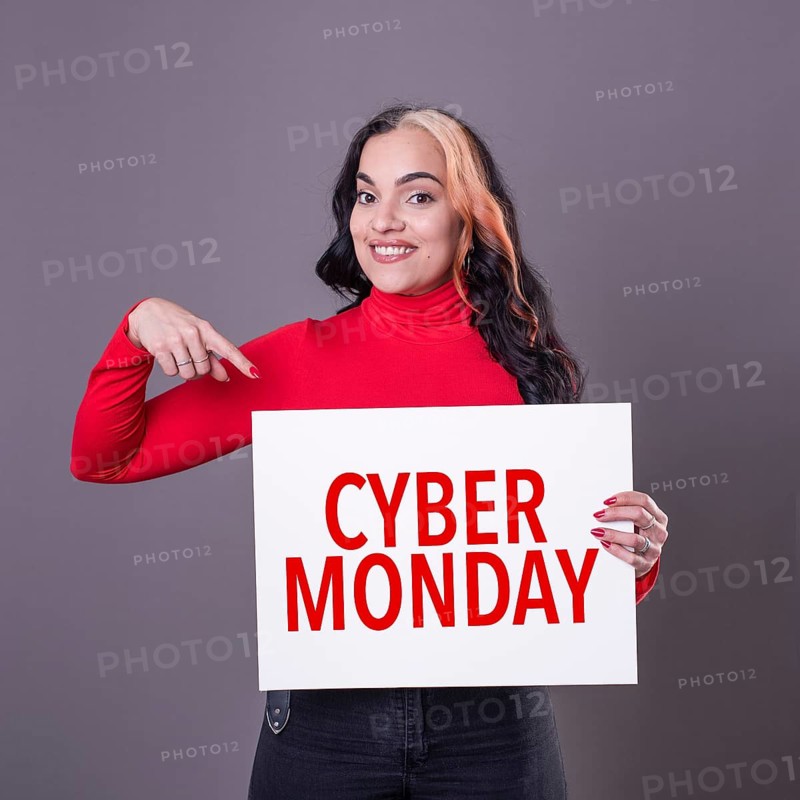 Beautiful woman pointing at a Cyber Monday sign. Commercial concept. Commerce