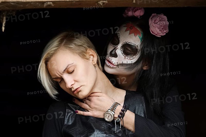 Female daemon with victim in hands. Face painting art
