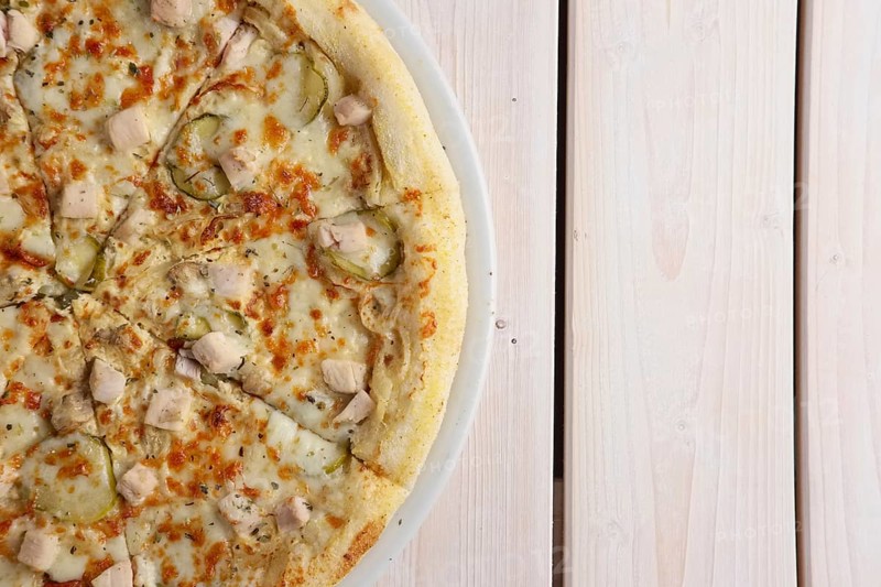 Fresh baked pizza with chicken fillet and pickled cucumber