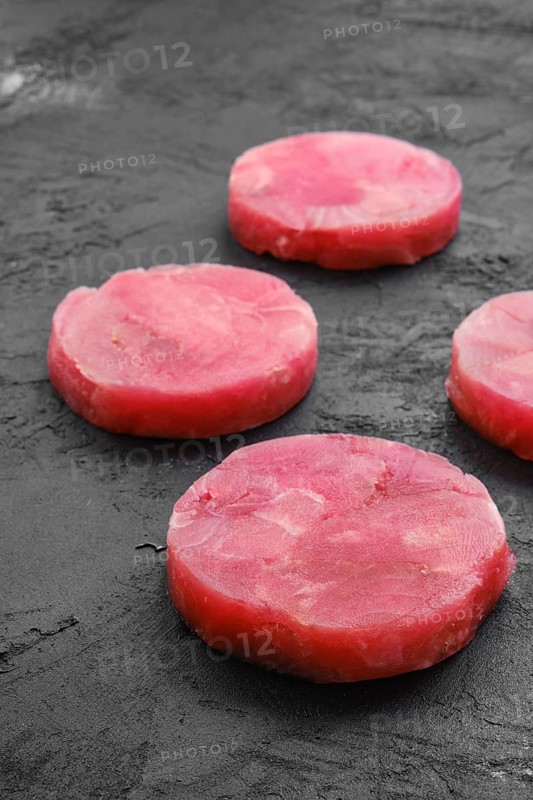 Fresh raw round tuna cutlet on wooden background