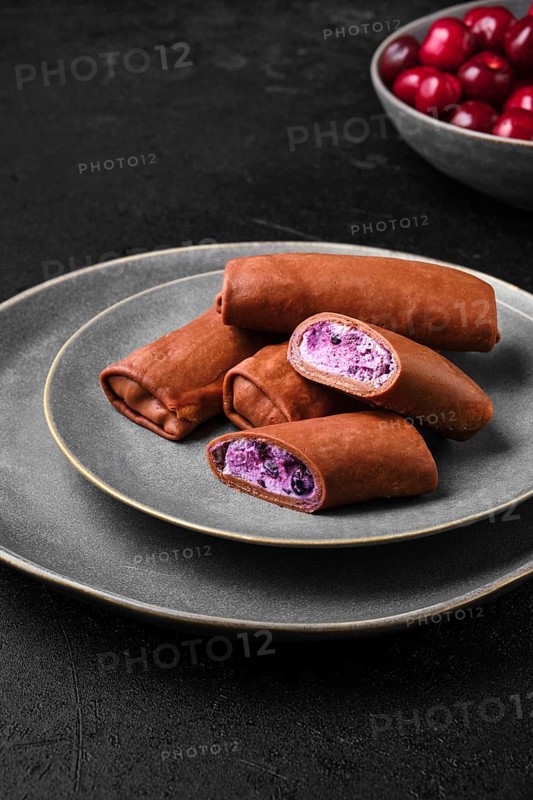 Thin chocolate pancakes stuffed with curd