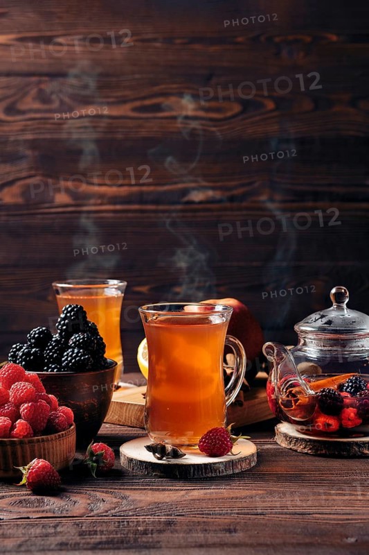 Freshly brewed fruit and herbal tea in kettle and two cups