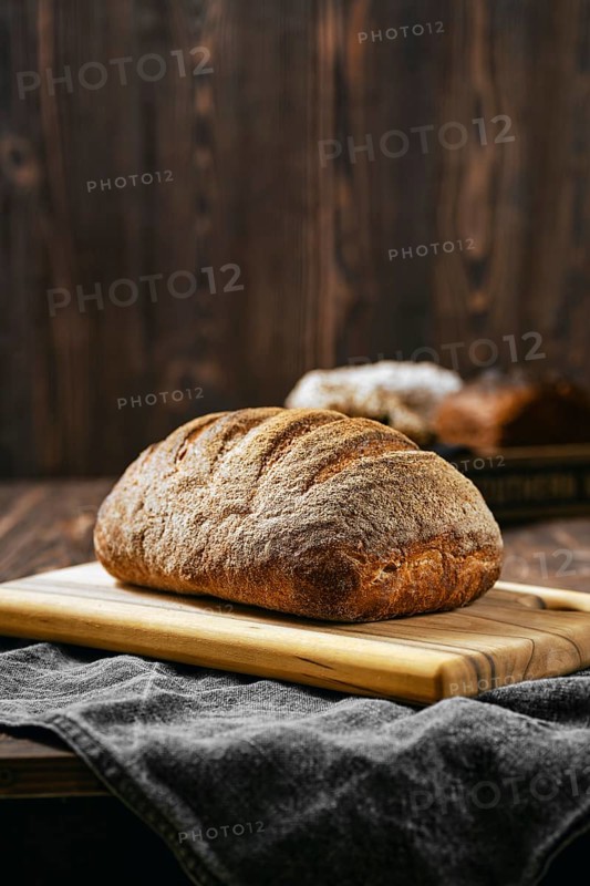 Loaf of artisan sourdough bread with porous texture on wooden table