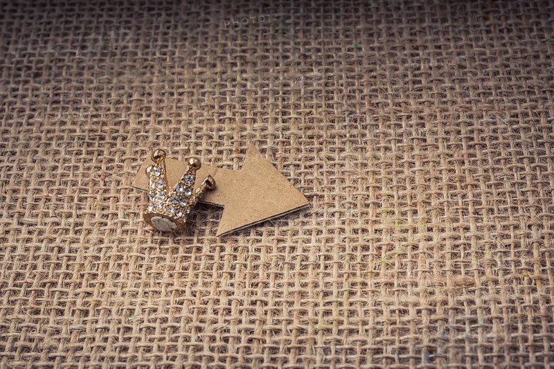 Mini crown and a paper arrow on canvas