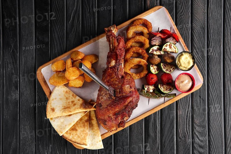Fried turkey thigh with grilled vegetables and snack for beer