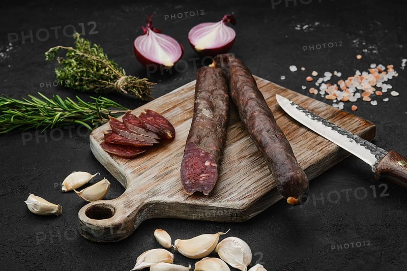 Beef dry aged sausage on wooden cutting board