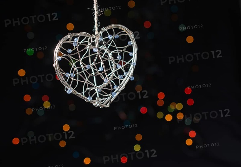 Heart shaped metal cage on a bokeh light background