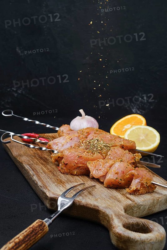 Pouring with sweet and spicy rub raw turkey meat on dark background