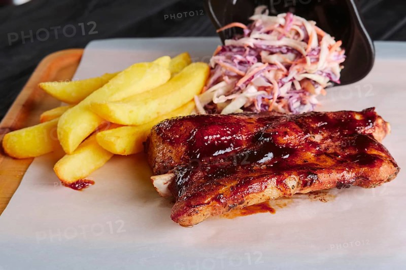 Rustic lunch. Grilled ribs with fried potato and red cabbage salad