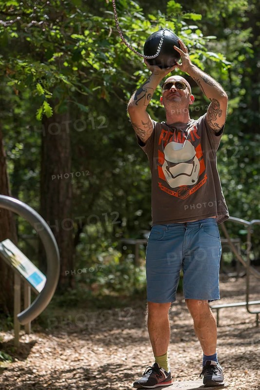 Man playing basketball on a trim trail