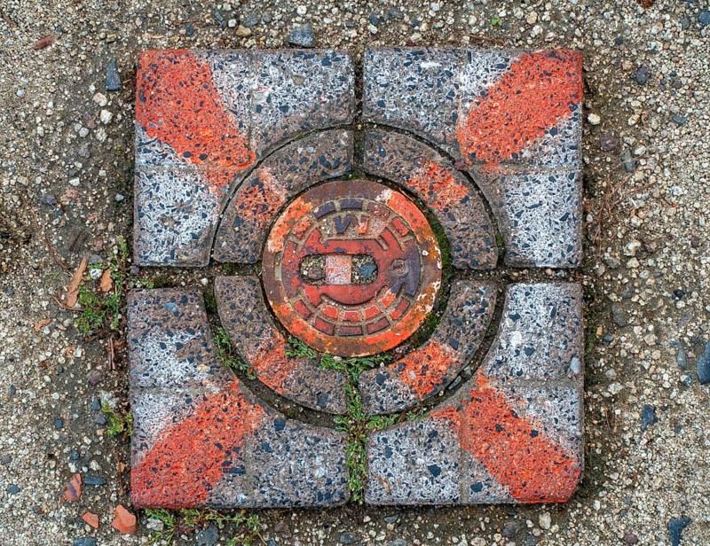 Red marked stone cover over a water hydrant connection