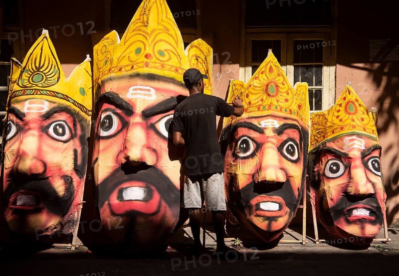 Artisan painting on a face of Ravana idol ahead of Dussehra Festival