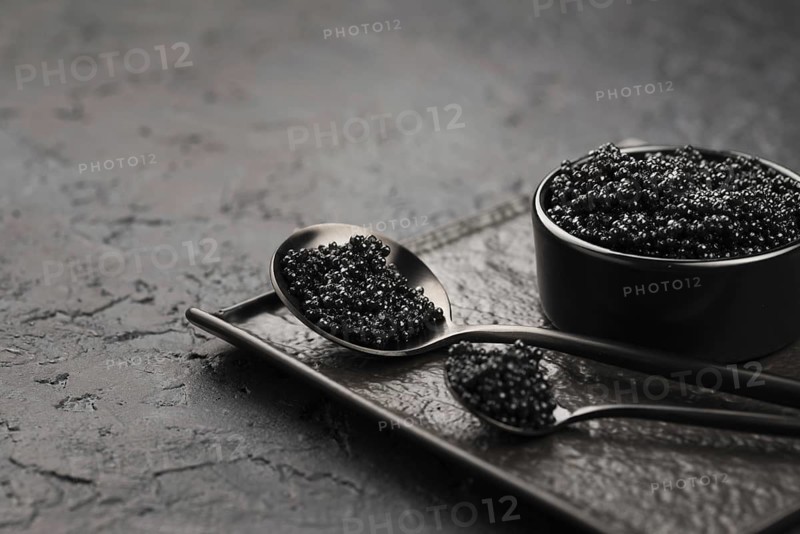 Black caviar bowl with spoons ladle