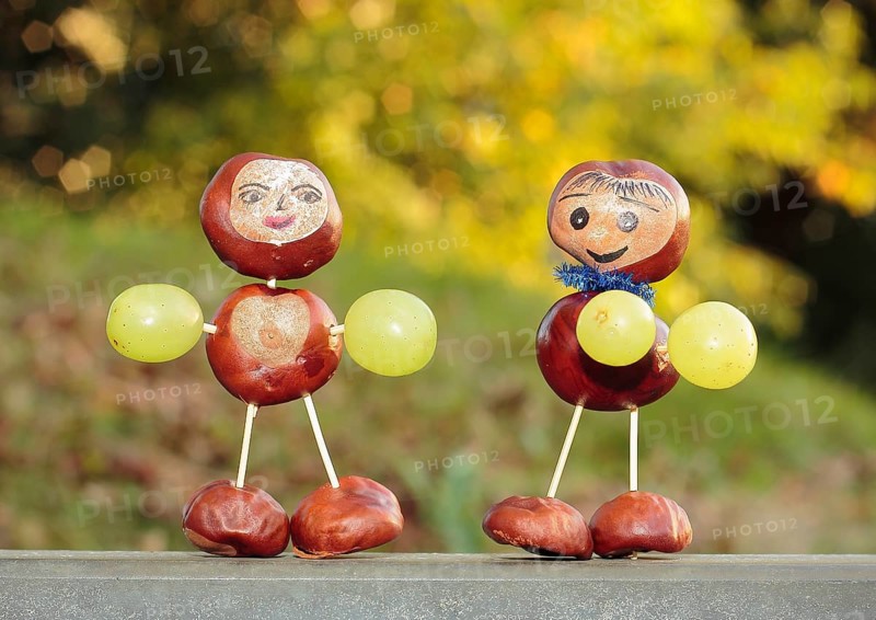 Two chestnut figures with grapes in the evening light